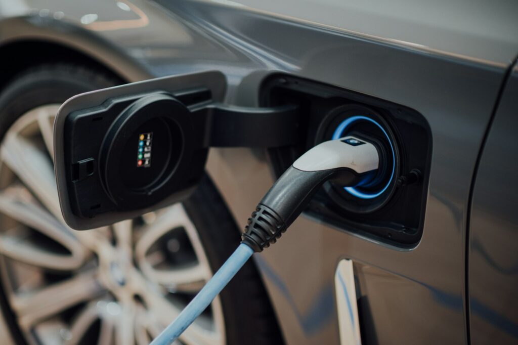 Conector de carga enchufado en un coche eléctrico, primer plano